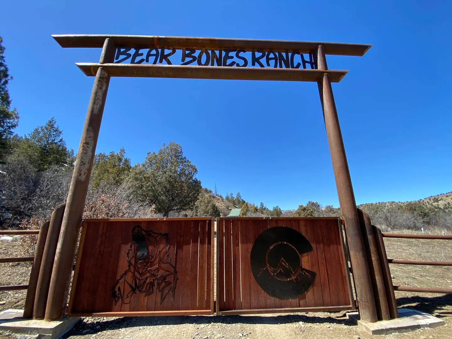 Bear Bones Ranch custom entrance sign with decorative metal gates and Colorado artwork
