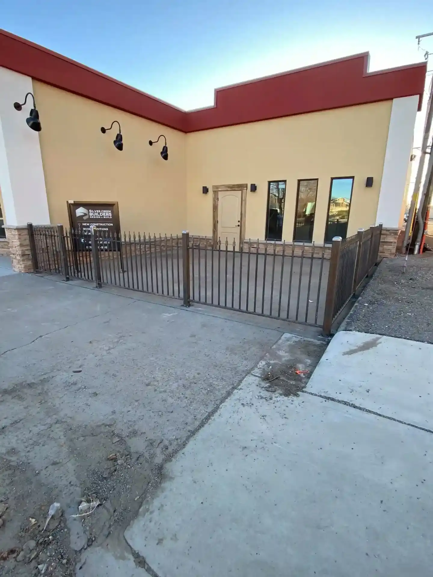 Commercial building with custom metal perimeter fencing and professional lighting