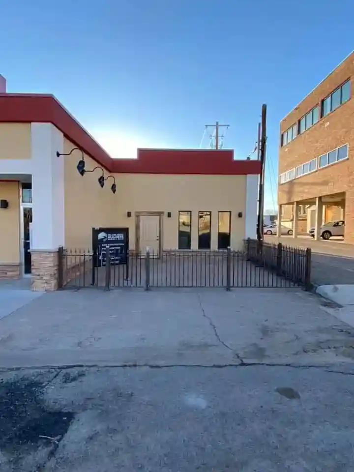 Side view of commercial building showing complete metal fencing installation