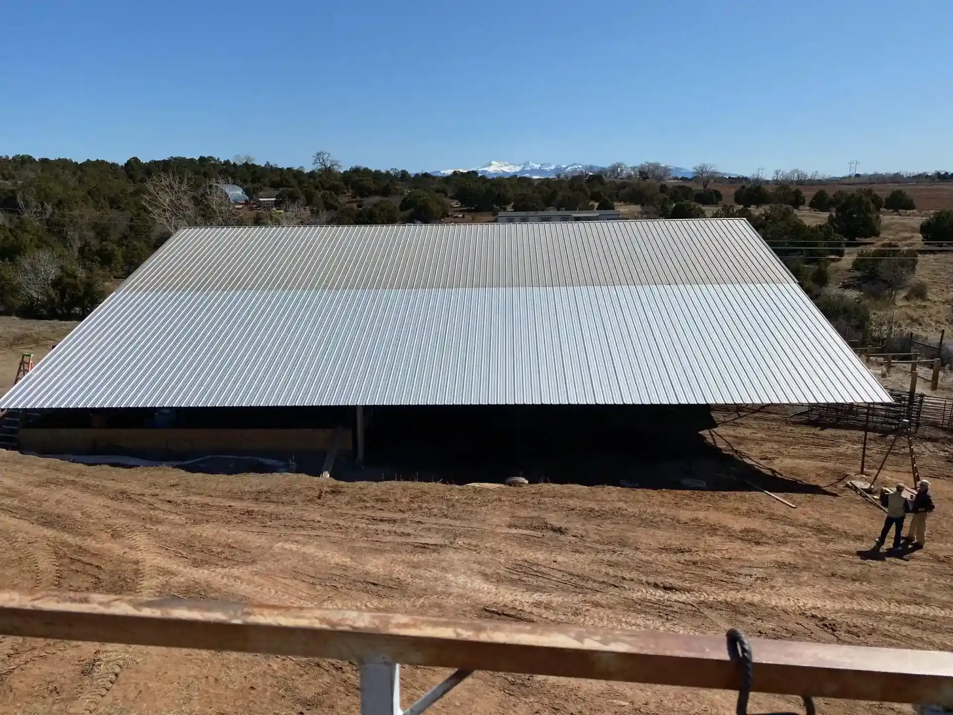 Completed large agricultural metal roof structure with scenic Colorado mountain views