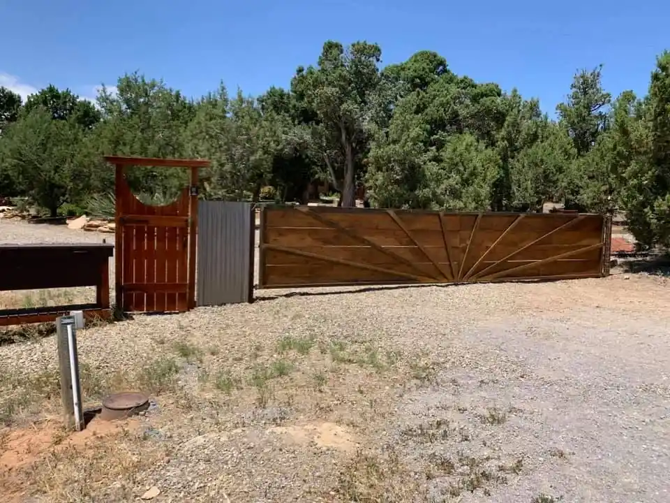 Custom fence combining wooden panels with decorative metal framework