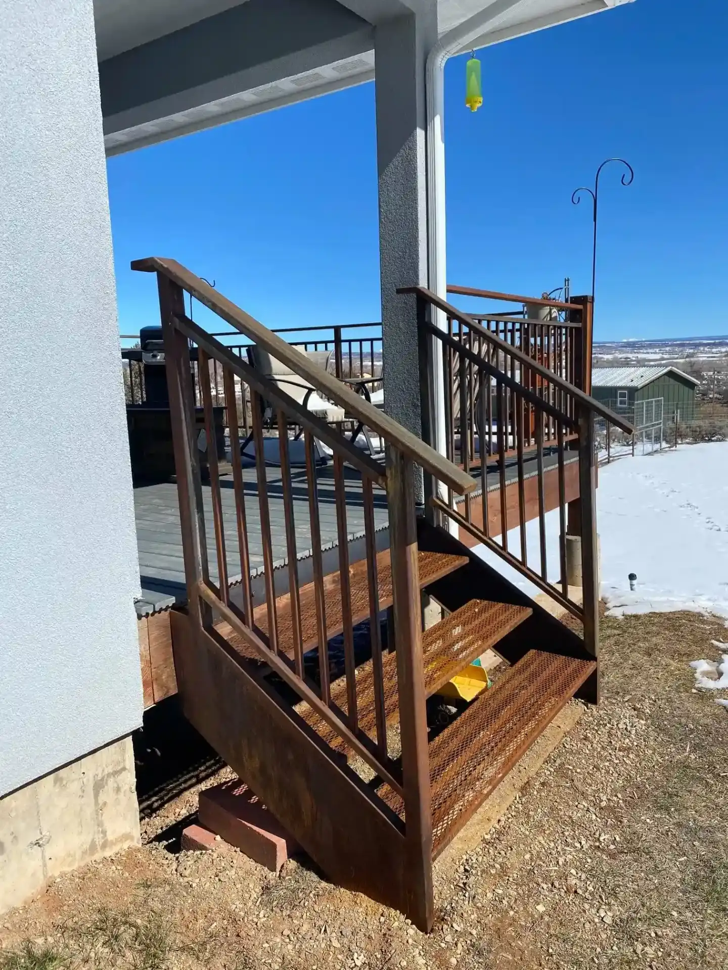 Exterior metal staircase with mesh railing system and mountain views