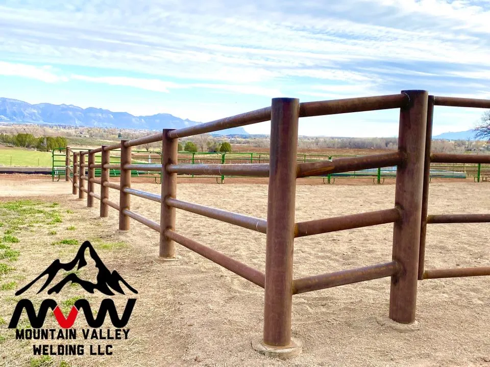 Professional ranch fencing with pipe rail design and mountain views